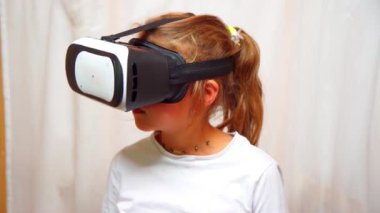 VR gözlük takan küçük kızın yakın çekim görüntüleri.