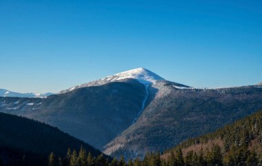 Parlak beyaz karla kaplı büyük bir dağ. Muhteşem kış manzarası. Idyllic kış zamanı.