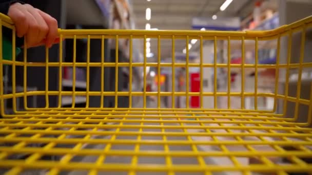 Люди Пустой Желтой Тележкой Проход Супермаркета Пустой Корзиной Через Полки — стоковое видео