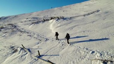 Kışın dağdaki iki yürüyüşçünün hava görüntüleri.