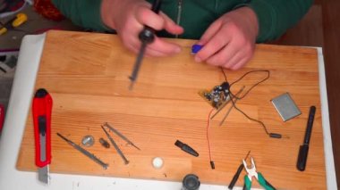 Basit elektrik devrelerinin yakın görüntüsü, elektrik bileşenleri, diyot, rezistanslar, lehimleme elektrik kabloları ve kabloları. El lehimleme istasyonu. Elektronik parçalar