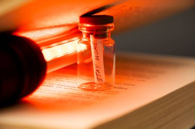 Evde kağıt kavanoz içinde kırmızı lambayla kitap içinde kal.