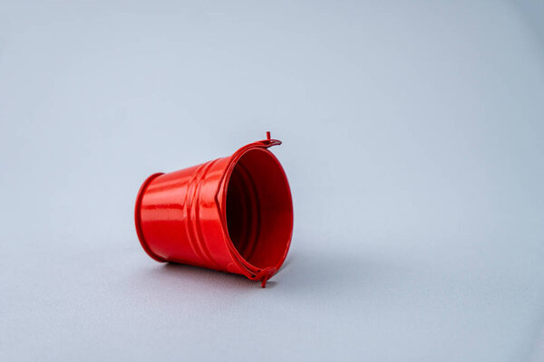 close-up shot of red bucket on grey background