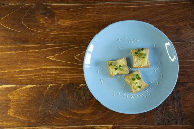 Kahvaltı için sandviç hazırla. Mavi tabakta mikro yeşillikli sandviçler ahşap arka planda lezzetli ve taze organik gıdalar sağlıklı kahvaltı konsepti