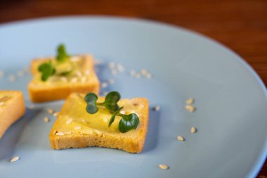 Kahvaltı için sandviç hazırla. Mavi tabakta mikro yeşillikli sandviçler ahşap arka planda lezzetli ve taze organik gıdalar sağlıklı kahvaltı konsepti