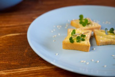 Kahvaltı için sandviç hazırla. Mavi tabakta mikro yeşillikli sandviçler ahşap arka planda lezzetli ve taze organik gıdalar sağlıklı kahvaltı konsepti