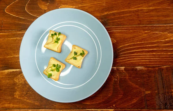 Kahvaltı için sandviç hazırla. Mavi tabakta mikro yeşillikli sandviçler ahşap arka planda lezzetli ve taze organik gıdalar sağlıklı kahvaltı konsepti