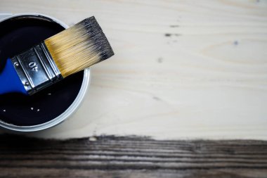Boya fırçasıyla ahşap arka planda duran alanı kopyala. Çalı üzerinde koyu kahverengi boya olan yakın plan boya fırçası. Ahşap yüzeydeki boya aletleri. Üst Manzara. Kopyalama. Klasik stil.