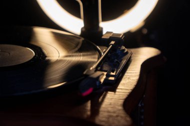 Vinil plak çalar. Eski tarz sinemagraf döngüsü vinil plak çalar. Vintage plakçının yakın görüntüsü. Müzik çalmak için eski tarz ses teknolojisi. Dönen vintage gramofon 
