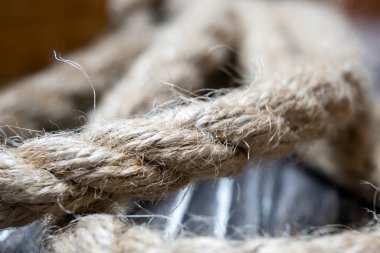 Close up view of an old aged rope on wooden background. Vintage cabin on the ship or boat. Close up view. Selective focus. 