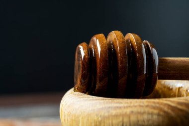 Bal-dipper 'dan damlayan aromatik bal. Kasedeki bal. Ahşap arka planda tahta kaplamalardan bal damlıyor. Seçici odak.