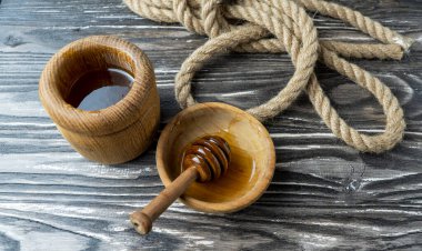 Bal-dipper 'dan damlayan aromatik bal. Kasedeki bal. Ahşap arka planda tahta kaplamalardan bal damlıyor. Seçici odak.