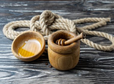 Bal-dipper 'dan damlayan aromatik bal. Kasedeki bal. Ahşap arka planda tahta kaplamalardan bal damlıyor. Seçici odak.