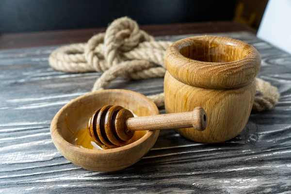 Bal-dipper 'dan damlayan aromatik bal. Kasedeki bal. Ahşap arka planda tahta kaplamalardan bal damlıyor. Seçici odak.