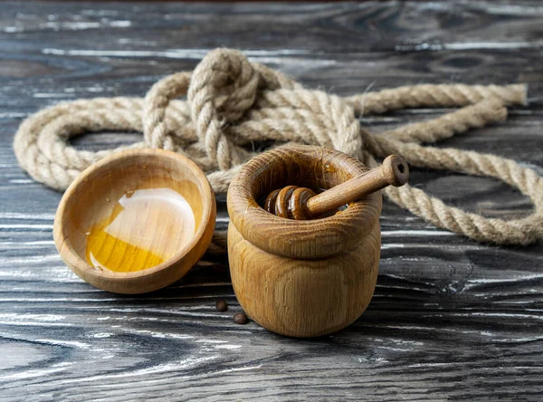 Bal-dipper 'dan damlayan aromatik bal. Kasedeki bal. Ahşap arka planda tahta kaplamalardan bal damlıyor. Seçici odak.