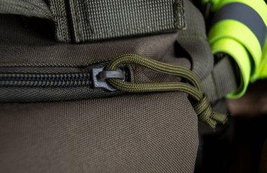 Sırt çantasının fermuarını açıyorum. Torbayı bağla. Toka kapanıyor. Fermuar kahverengi çanta tekstil aksesuarları. Kopçanın yakın görüntüsü.