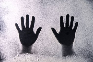 Top view of the hands silhouette made with flour on dark background. Flour contrasting background. Food preparation process. Concept of bakery.