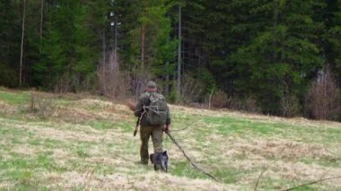 Orta yaşlı erkek avcının Karpat Ormanı, Ukrayna 'da köpeğiyle çekilmiş görüntüleri. 
