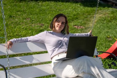 Dizüstü bilgisayarı üzerinde çalışan serbest çalışan genç bir bayan.