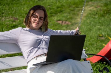 Dizüstü bilgisayarı üzerinde çalışan serbest çalışan genç bir bayan.