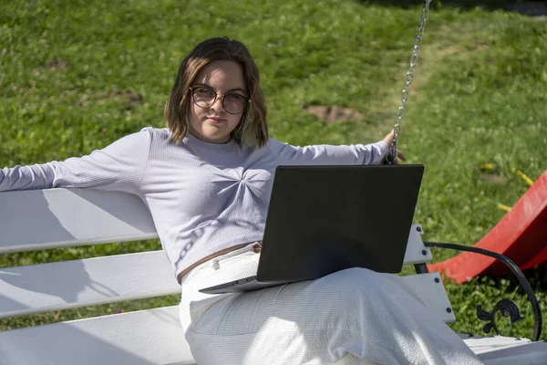 Dizüstü bilgisayarı üzerinde çalışan serbest çalışan genç bir bayan.