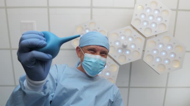 A doctor with an enema in his hands stands above the patient. — Stock Video