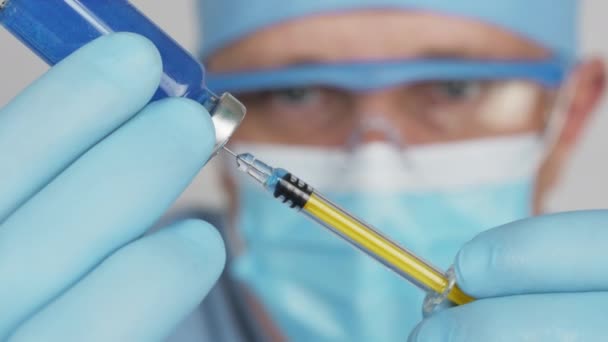 Médecin remplit la médecine dans une seringue d'une ampoule — Video