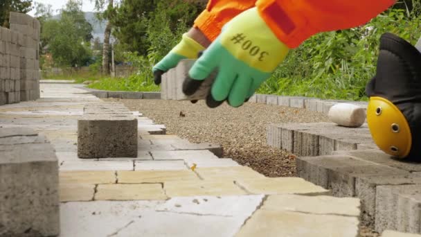 Construction worker makes new sidewalk pavement with stone bricks — Stock Video