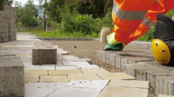 Trabajador de la construcción hace nuevo pavimento de acera con ladrillos de piedra — Vídeos de Stock