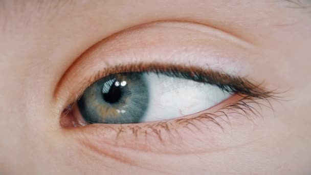 Niebieskie oko młodej dziewczyny rozgląda się dookoła — Wideo stockowe