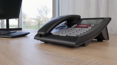 Masa başı telefon geliyor. Ofis sabit telefonu, yakın çekim görüntüsü.
