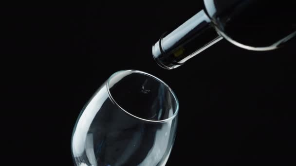 Witte Wijn Gieten Uit Fles Wijnglas Zwarte Achtergrond — Stockvideo