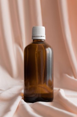 Yumuşak pembe tekstil üzerinde ilaç şişesi modeli..