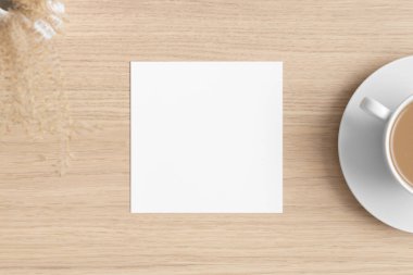 Kare davetiye maketi. Kuru bir çiçekle ahşap masa..