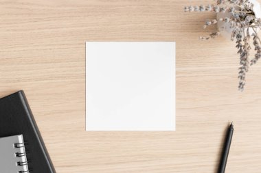 Ahşap masada lavanta ve çalışma alanı aksesuarlarıyla kare davetiye maketi..