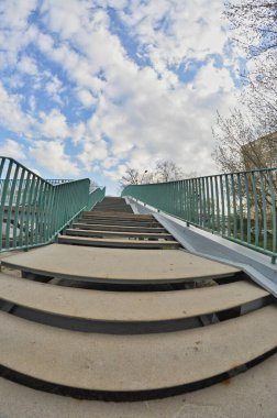 Yeşil bulutlu gökyüzü ile köprüdeki yolda ayak sesleri