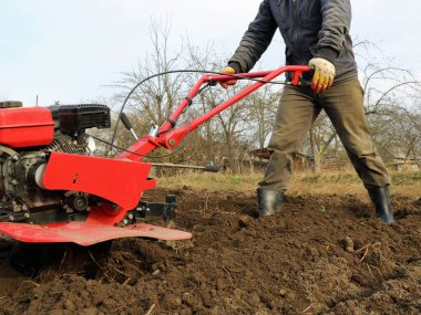 Toprak ekimi, saban ekili bir traktör, motorlu tarım arazisi sürme, kırmızı demir benzin küreme çiftçisinin mevsimsel çalışma süreci.