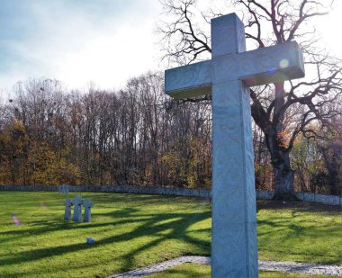 Ormanlarla çevrili yeşil çayırlardaki bir anıt parktaki basit bir taştan haç savaşta ölenlerin kutsal anısının sembolü olarak, ölen askerlerin anısına bir anıt.