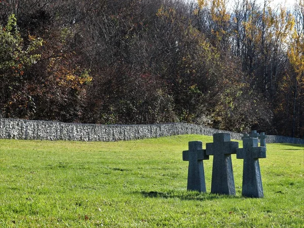 秋の森の間に石塀で囲まれた緑の草原の上に立っている3列に花崗岩のケルト人の十字架 死んだ兵士や囚人の墓とカトリック墓地 — ストック写真