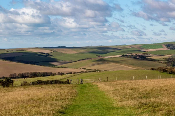 Looking along a pathway on the South Downs Way in Sussex, with the coast at Brighton in the far distance