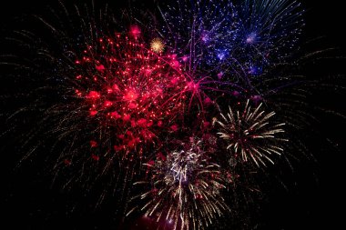 Red, white and blue fireworks in the night sky clipart