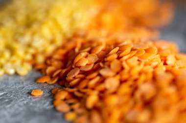 Kırmızı ve sarı mercimekler gri arka planda, seçici odaklı