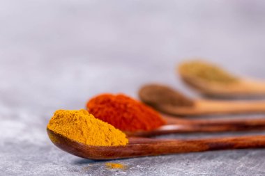 Ahşap kaşıklarda çeşitli renkli baharatlar, sığ bir alan derinliği var.