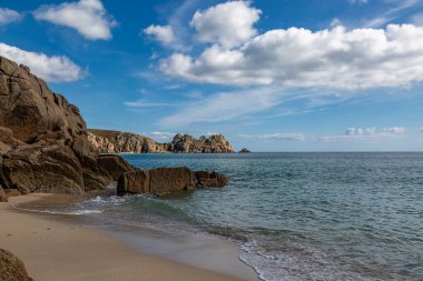 Cornwall 'un güney kıyısındaki Porthcurno' da kaya oluşumları ve kumlu plaj.