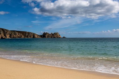 Cornwall 'un güney kıyısındaki Porthcurno' da kaya oluşumları ve kumlu plaj.