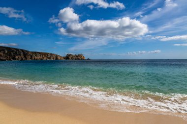 Cornwall 'un güney kıyısındaki Porthcurno' da kaya oluşumları ve kumlu plaj.