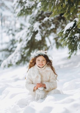 Karlı kış yürüyüşünde oynayan mutlu çocuk. Küçük kız tatilin tadını çıkarıyor. Hafif arkaplanda bir çocuğun portresi.