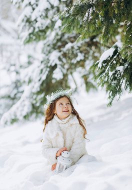 Karlı kış yürüyüşünde oynayan mutlu çocuk. Küçük kız tatilin tadını çıkarıyor. Hafif arkaplanda bir çocuğun portresi.