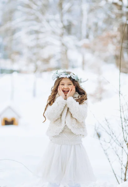 Szczęśliwa Mała Kręcona Dziewczynka Wieńcu Biały Płaszcz Bawiący Się Śniegiem — Zdjęcie stockowe
