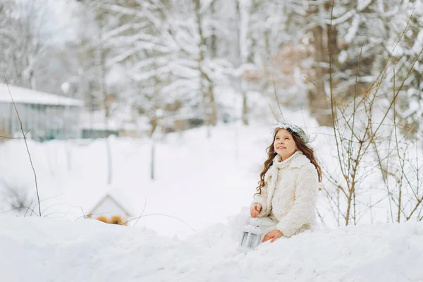 Маленькая Очаровательная Маленькая Девочка Рождественском Венке Сидит Снегу Фонариком Руках — стоковое фото